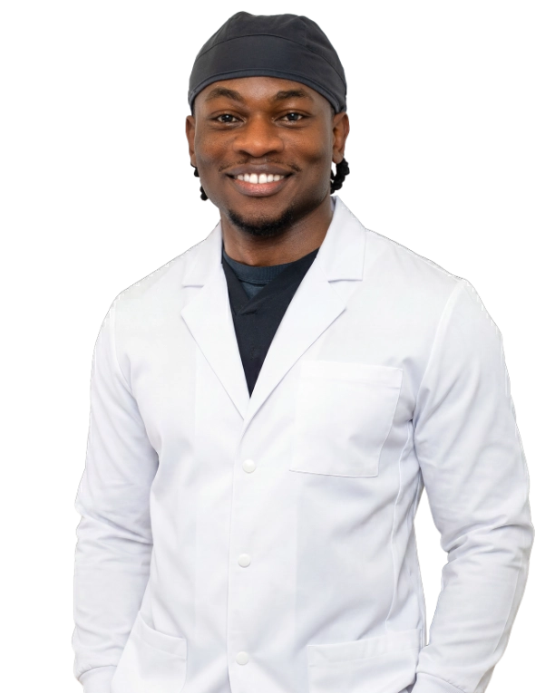 Dr_Byron_665x765 Professional headshot of Dr. Baron Ekeledo wearing a white lab coat and dark headband, smiling at the camera against a black background. This is a standard medical professional portrait used for clinic or practice identification.