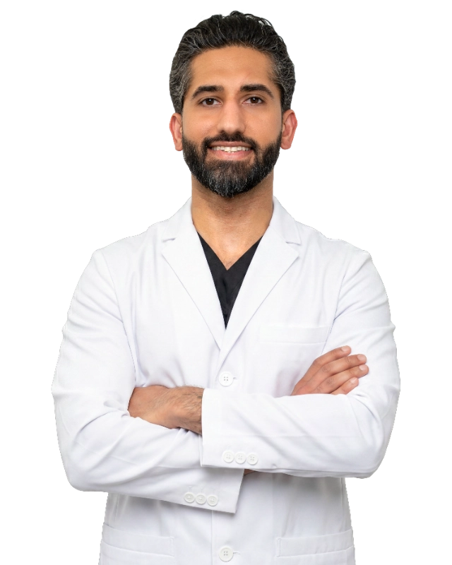 VTC_DrYousaf_Coat_1_2978x3723_optimized Professional headshot of Dr. Usman Yousaf wearing a white lab coat, smiling at the camera against a black background. This is a standard medical professional portrait used for clinic or practice identification.